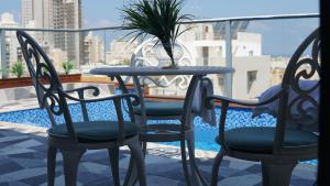 a table and chairs on a balcony with a plant at Luxury Rooftop Apartment in Netanya in Netanya