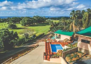 eine Luftansicht eines Hauses mit einem Golfplatz in der Unterkunft Rarotonga GolfSeaView in Rarotonga