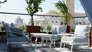 a group of chairs and a table on a balcony at Luxury Rooftop Apartment in Netanya in Netanya