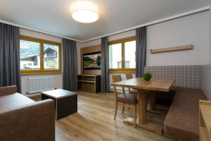a living room with a table and a couch at Apart Val Sula in Sankt Anton am Arlberg +24 photos