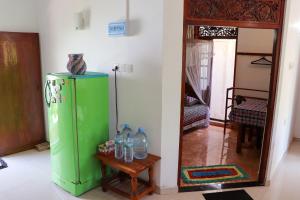 a green refrigerator in a room with a mirror at Sun Hopes in Mirissa
