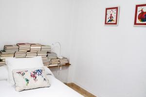 un dormitorio con una pila de libros en una cama en La Librería de Viana, en Córdoba