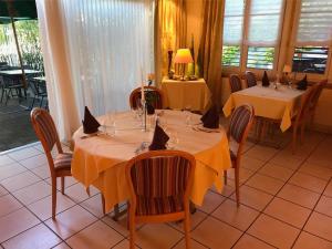 a dining room with two tables with yellow table cloth at Hotel Eintracht in Oberbipp