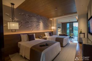 a hotel room with two beds and a tv at Jinshuo Holiday Hotel in Mianyang