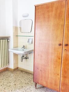 a bathroom with a sink and a wooden door at Ostello delle cartiere in Toscolano Maderno +94 photos