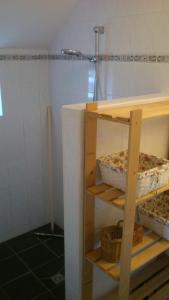 a bathroom with a shelf in the corner of a room at Pipowagen Lidewei Groningen Westerwolde unieke ligging met eigen tuin en vrij uitzicht over veld naar natuurgebied in Onstwedde