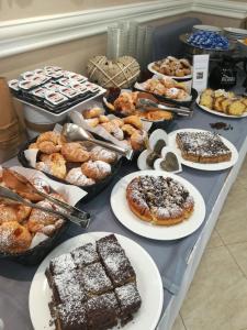 a table full of different types of pastries and desserts at c-hotels Club House Roma in Rome