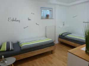 ギュンツブルクにあるEisele Heikeのベッド2台とソファが備わる客室です。
