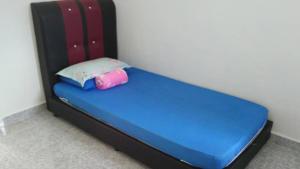 Bett mit blauer Matratze und rosa Kissen in der Unterkunft Rehat Penginapan Famili in Kampung Kuala Besut