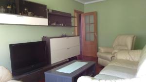 - un salon avec une télévision à écran plat et deux chaises dans l'établissement Good Stay Lugo Apartment, à Lugo