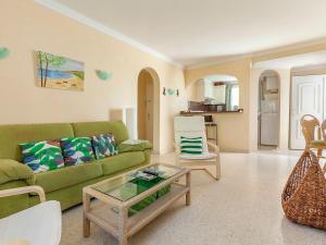 a living room with a green couch and a table at Apartment Club Sevilla I-3 by Interhome in Casas Devesa +10 photos