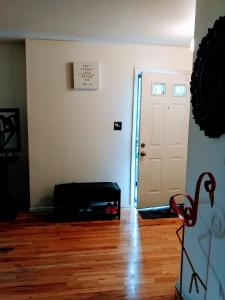 a room with a white door and a wooden floor at Pleasant Place Rooms in Queens