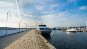 a boat is docked next to a dock with boats at Hotel Molo in Sopot