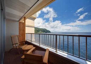Un balcón con sillas y vistas al océano. en Hamanoyu, en Higashiizu