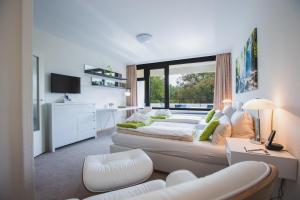 Großes Zimmer mit 2 Betten und einem Sofa in der Unterkunft Eilenriedestift Appartements in Hannover
