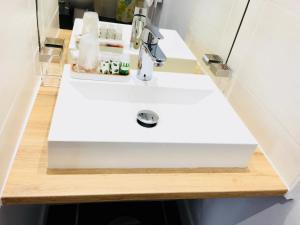 a bathroom with a white sink on a wooden counter at Appart Hôtel Boulogne Résidence in Boulogne-Billancourt +22 photos