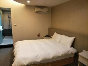 Postel nebo postele na pokoji v ubytování Shun-yi Business Hotel