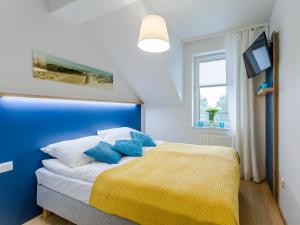 ein blau-weißes Schlafzimmer mit Bett und Fenster in der Unterkunft Feniks SPA Apartments 10 by Jantar Apartamenty Kołobrzeg in Kołobrzeg + 92 Fotos