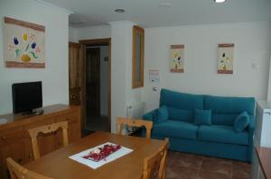 a living room with a blue couch and a table at Apartamentos Torremar in Isla