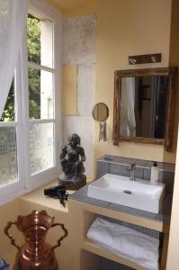 y baño con lavabo y espejo. en Domaine de Lalat - B&B with en-suite bathrooms all rooms with garden views, en Montembœuf