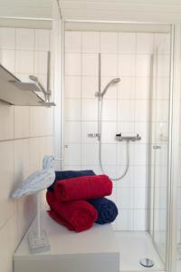 a bathroom with a shower and a pile of towels at Haus "Zur Düne" in Norddorf