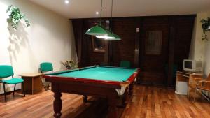 a room with a pool table in a room with chairs at Hotel Junior in Zamość