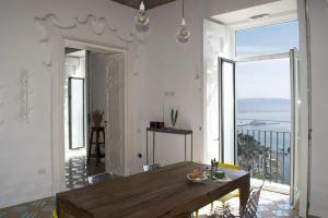 een eetkamer met een tafel en een groot raam bij Il Rigiuolo - Holiday Home in Vietri
