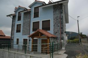 una casa azul con una valla delante de ella en Apartamentos Torremar, en Isla