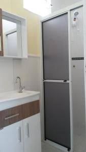 um frigorífico preto numa cozinha ao lado de um lavatório em Suítesmariscal Suítes Mariscal em Bombinhas