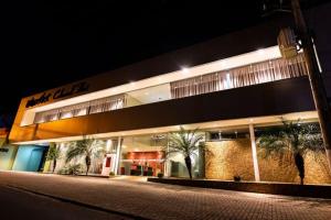 a building with palm trees in front of it at night at Colonial Flat Hotel in Itapetininga