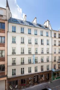 ein großes weißes Gebäude mit vielen Fenstern in der Unterkunft Hôtel La Nouvelle République & Hammam in Paris