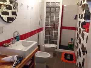 a bathroom with a white toilet and a sink at Casa Auri in Faial da Terra +28 photos