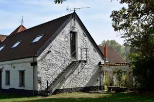 une maison en pierre avec un escalier sur son côté dans l'établissement Cense de Lalouette, à Saint-Ghislain