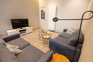 Una sala de estar con un sofá y un televisor en Blossom & Bloom, en Brujas