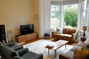 a living room with two couches and a television at Cranford Holiday House in Crieff