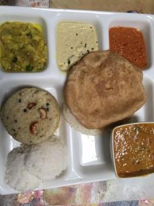 a lunch box with different types of food in it at Maruti Villa in Kodaikānāl