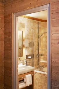 y baño con bañera, lavamanos y ducha. en Les Trois Vallées, a Beaumier hotel en Courchevel