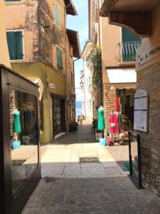 a narrow street with clothes on display in a store at VICOLOVOLTA16 in Torri del Benaco