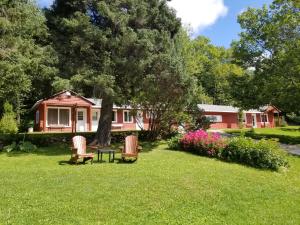 uma casa com duas cadeiras e uma mesa no quintal em Kan-à-Mouche Pourvoirie Auberge et Chalets em Saint-Michel-des-Saints