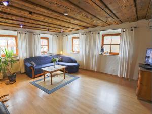 ein Wohnzimmer mit einem blauen Sofa und einem Tisch in der Unterkunft Bio-Ferienhof Scheckenbauer in Höttingen