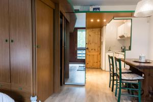 una cocina con armarios de madera, mesa y sillas en Monolocale Cielo Alto, en Breuil-Cervinia