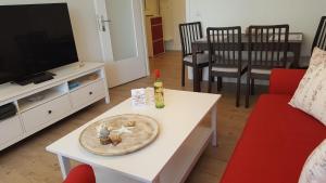 韋斯特蘭的住宿－App-Syltliebe-Haus-Ankerlicht-Whg-70，客厅,配有桌子和盘子