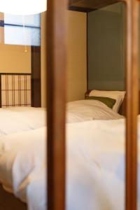 2 bedden in een kamer met witte lakens bij Higashiyama Chitaru in Kanazawa in Kanazawa