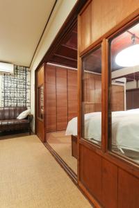 een kamer met een bed en een grote houten deur bij Higashiyama Chitaru in Kanazawa in Kanazawa