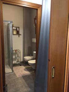 e bagno con servizi igienici e porta doccia in vetro. di Elegant Apartment a Vicenza