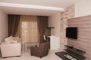 a living room with a couch and a tv on a wall at Hotel Laguna in Ulcinj