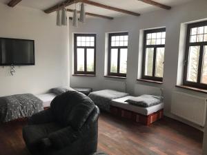 a living room with a couch and a chair at Portus Apartment in Smržovka