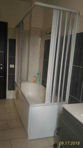a bathroom with a bath tub with a glass wall at B&B Madau in Samughèo