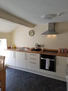 a kitchen with white cabinets and a sink and a stove at Bridge Street in Aberystwyth