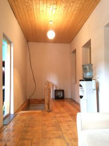 una stanza vuota con un soffitto in legno e un frigorifero di Guest house lela a Mestia Altre 25 foto
